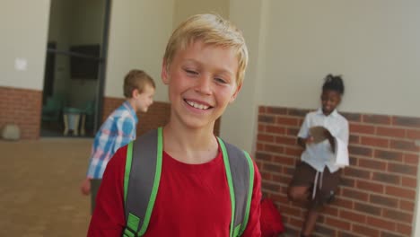 Video-of-happy-caucasian-boy-standing-in-front-of-school