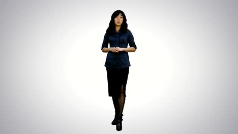 young attractive asian woman talks to camera, presenting something on white background