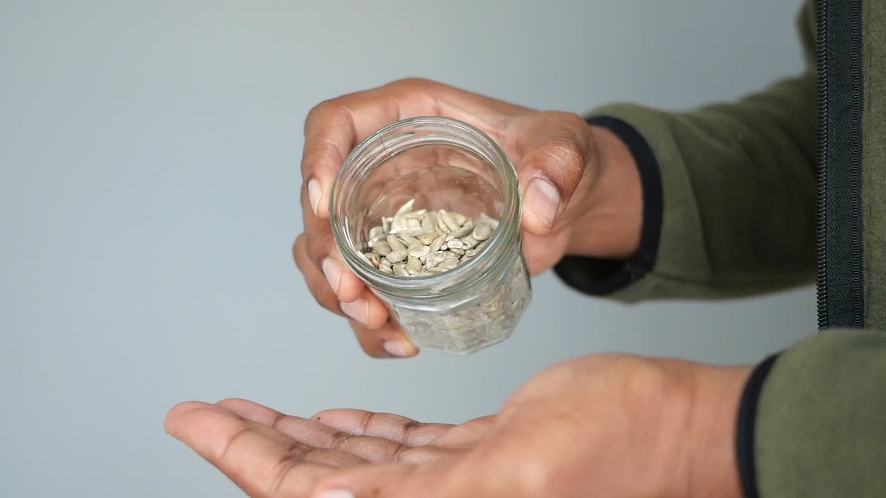 persona que sostiene un frasco de semillas de girasol
