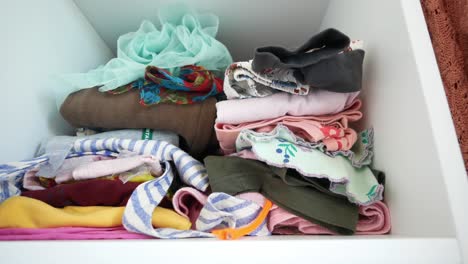 a closet shelf with neatly folded clothes