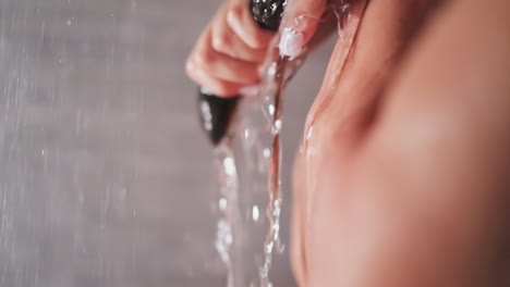 woman wrings water out of long hair in shower closeup. lady enjoys hair washing in clear water sprays at home. woman does hygienic procedures