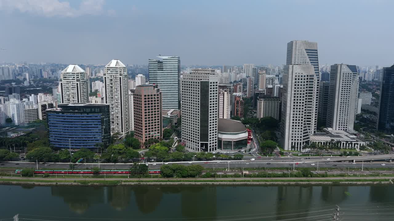 Train And Traffic Along The Modern Buildings and The Pinheiros River In Sao Paulo, Brazil. - aerial shot