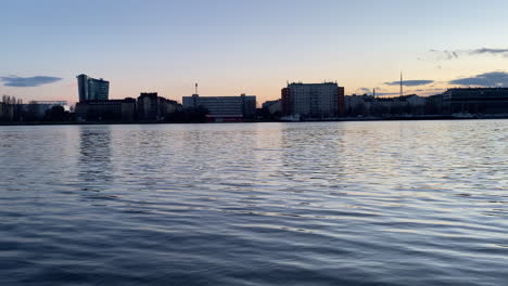 city skyline at sunset over calm river