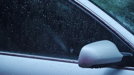 raindrops form gentle trails on car glass during cinematic slow motion rainfall