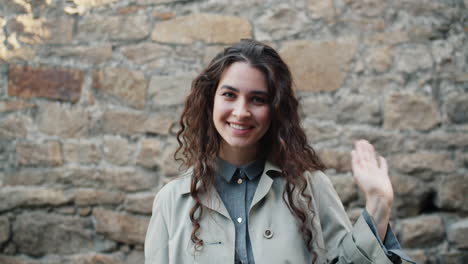 young woman smiling and waving