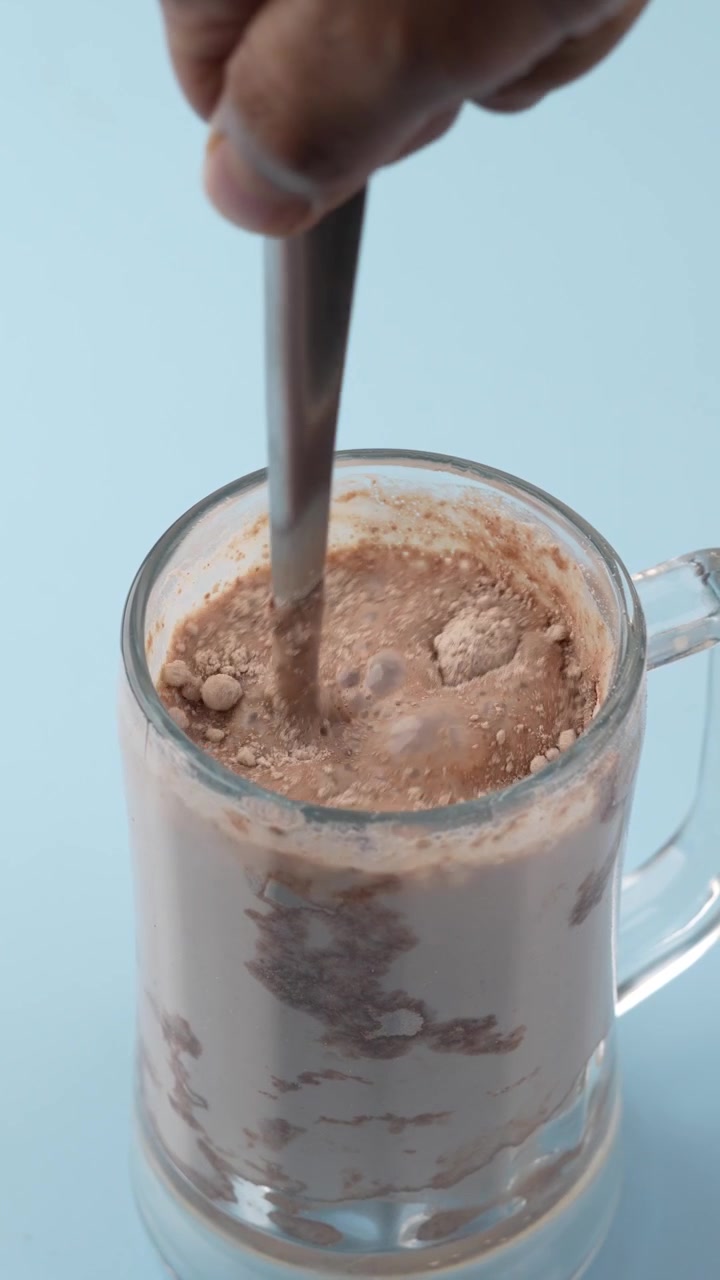 Proteína vegetal en polvo mezclándose en un vaso con cuchara
