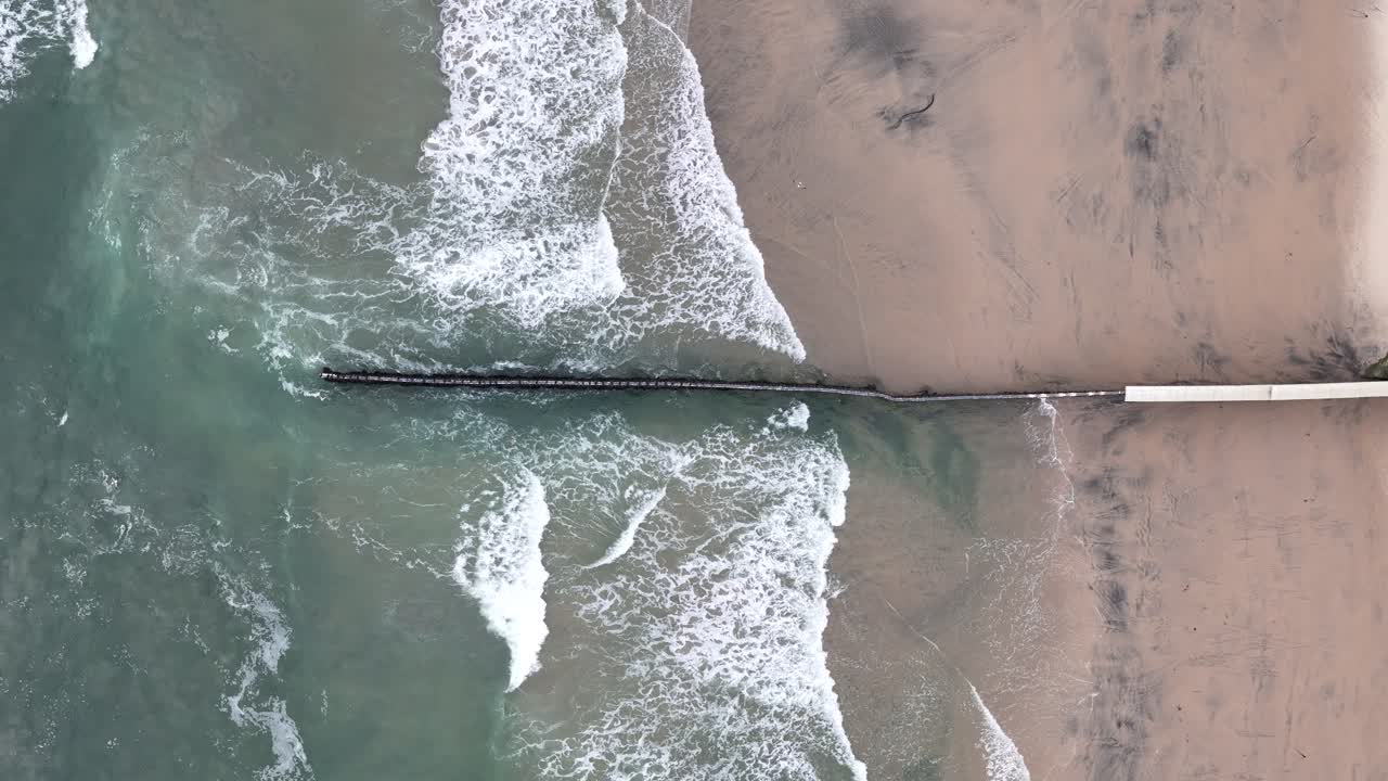 aerial shot of waves and beach at mexico us border in tijuana