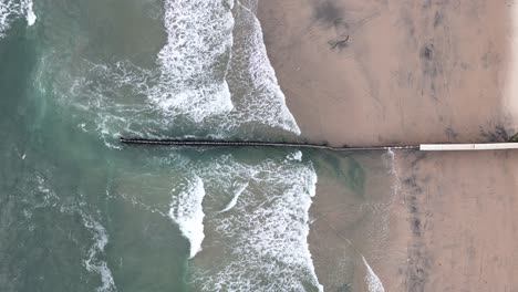 aerial shot of waves and beach at mexico us border in tijuana