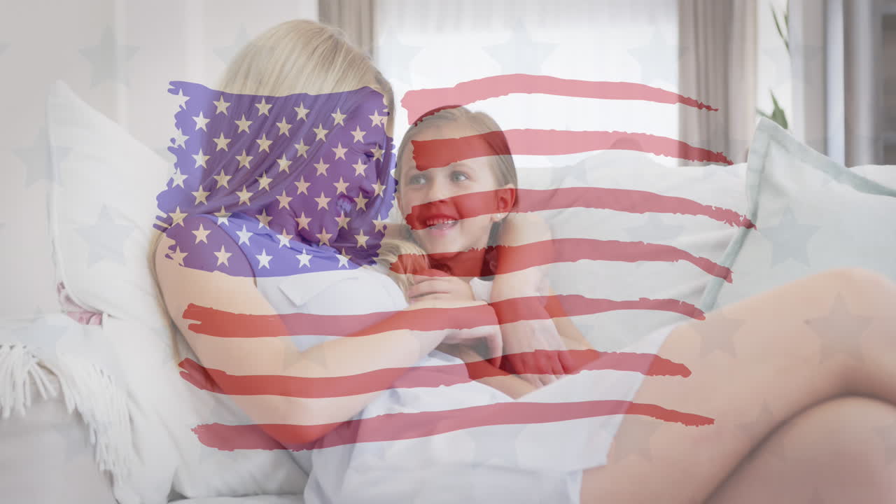 animación de la bandera de los estados unidos ondeando sobre una madre y una hija caucásicas sonrientes en el sofá