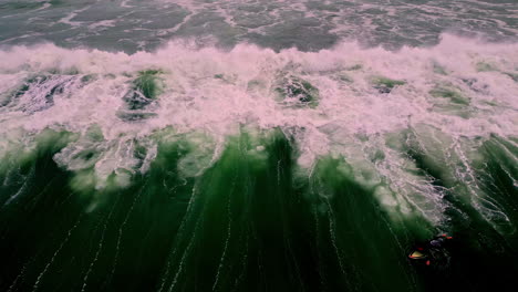 forceful ocean wave crashing near coastline, aerial view