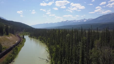 aerial rises above coal train, river in bow valley, canadian rockies