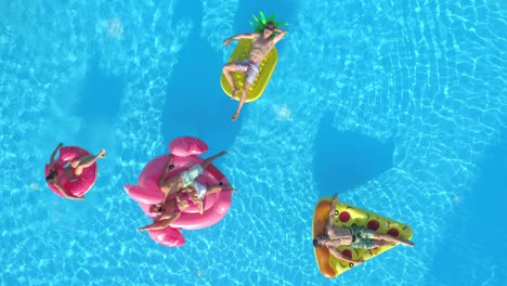 aerial: a group of young friends enjoys their weekend at a fun pool party.