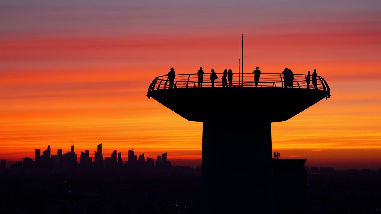 Silhouetted Observation Platform At Sunset With Group Of People Standing Along Railing On Elevated Tower,