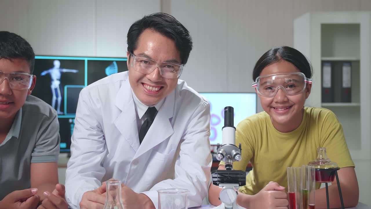 Young Asian Boy, Girl And Teacher Smiling To Camera In Classroom. Study With Scientific Equipment