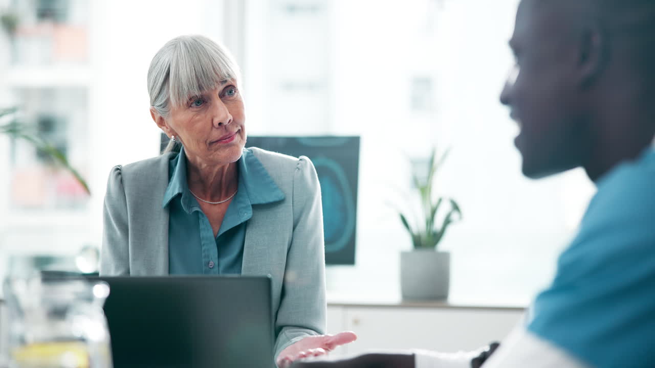 Doctor consulting with elderly patient in office