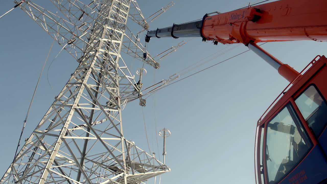 grúa industrial que construye el poste de la línea eléctrica de alta tensión, vista desde abajo