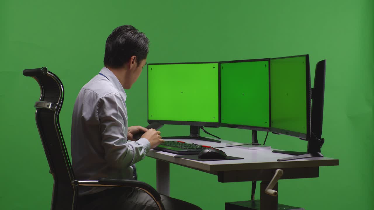 녹색 화면으로 컴퓨터에서 일하는 사업가