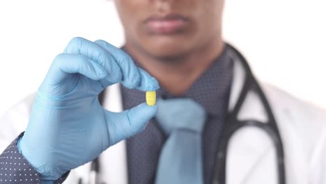médico con una píldora amarilla