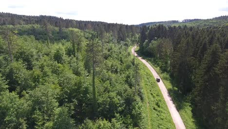 Un-Coche-Circulando-Por-Un-Camino-De-Tierra-En-El-Bosque.-Vista-Por-Drone,-Bosque-De-Verdún