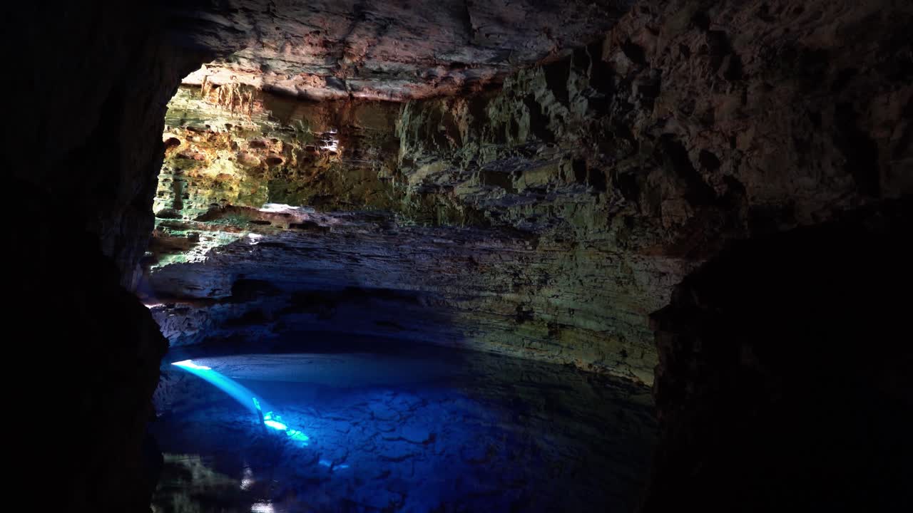 tiro inclinado hacia arriba de la impresionante cueva natural piscina el pozo encantado o poço encantado en el parque nacional chapada diamantina en el noreste de brasil con hermosas aguas azules claras y un rayo de sol