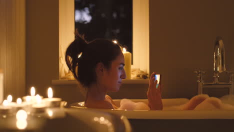 una mujer feliz enviando mensajes de texto en su teléfono inteligente durante