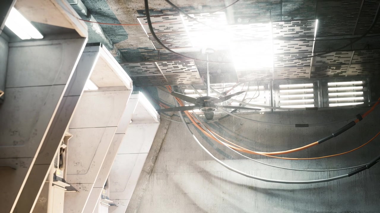 Espaço industrial com ventiladores de teto e cabos em ambiente iluminado