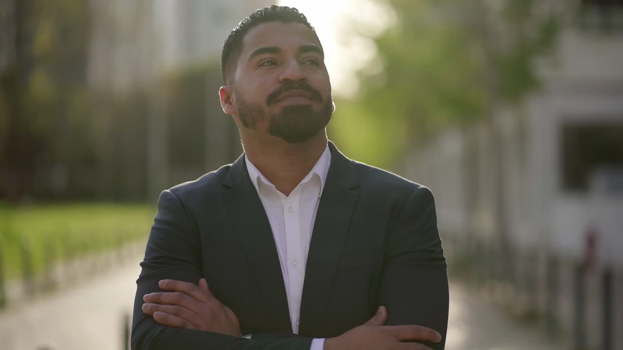 hombre de negocios feliz de pie con los brazos cruzados en la calle