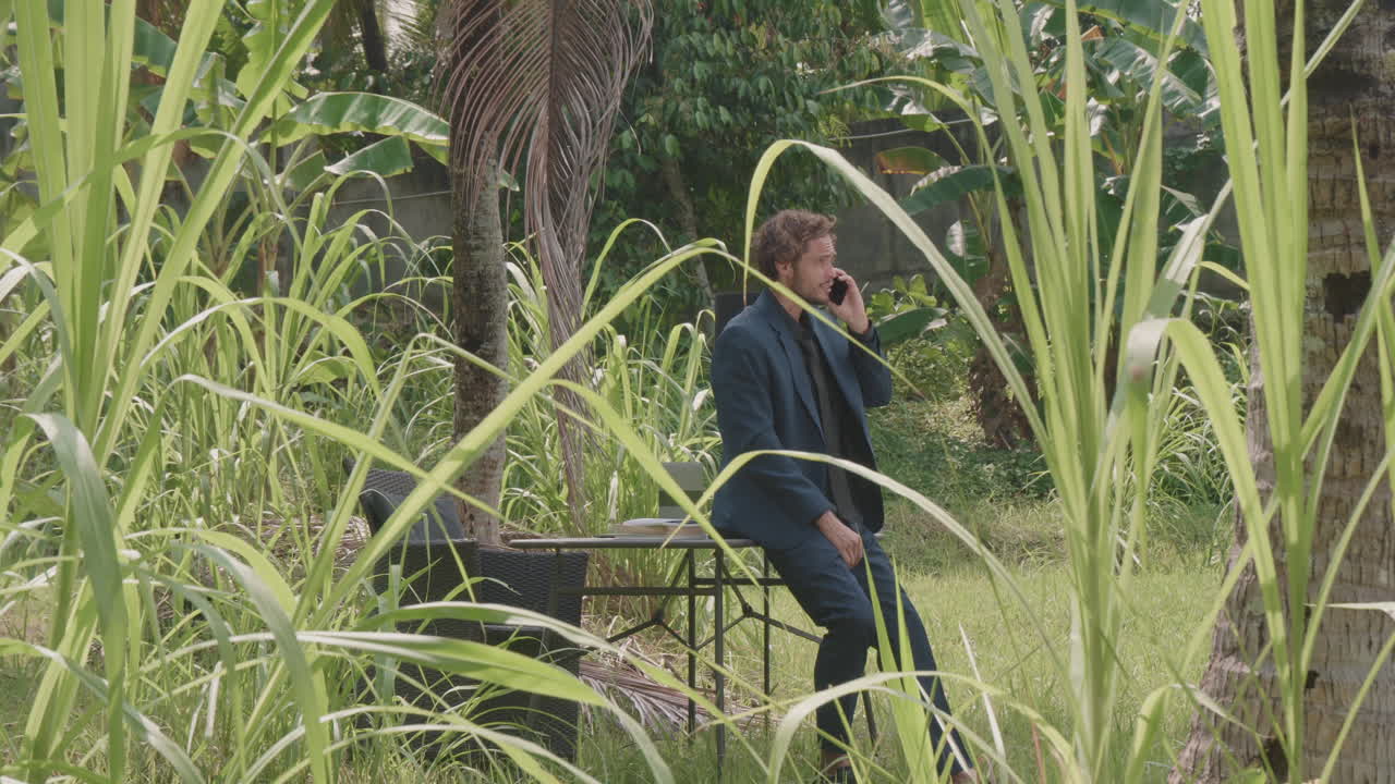 Business Man Talking On Phone Among Palm Trees