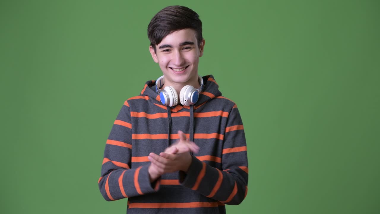 joven y guapo adolescente iraní contra un fondo verde