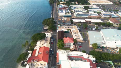 Aerial-coast-town-Lahaina,-Maui-Hawaii,-USA,-cars-driving-near-beach-with-calm-waves