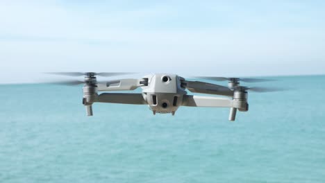 drone hovering over ocean with blue sky