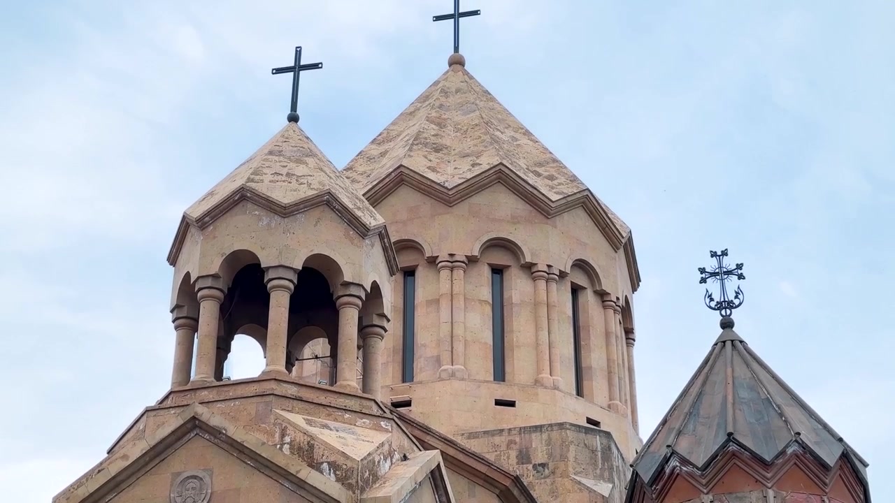 summer in Armenia nature landscape of historic monastery cathedral courtyard exterior facade colorful volcanic tuff stone architecture carving detail archway entrance religious christianity landmark