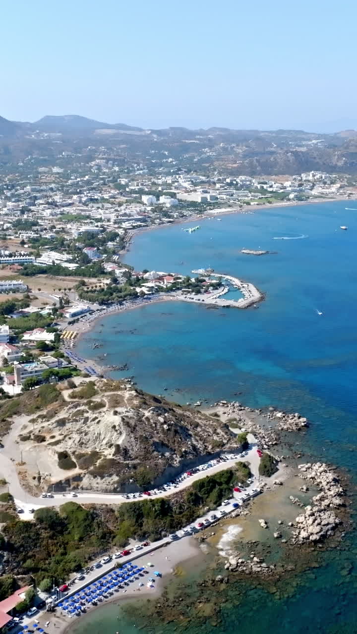 Yunanistan'da bir yaz günü Faliraki liman kıyısı ve kumlu plajların dikey havadan görüntüsü.