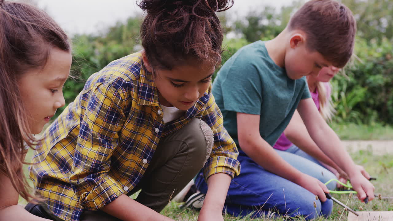 grupo de niños en un viaje de acampada al aire libre aprendiendo a hacer fuego