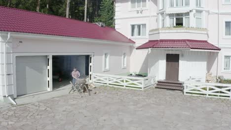 man chopping wood in front of garage