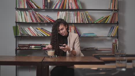 mujer joven usando un teléfono inteligente en un café