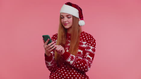 Chica-En-Suéter-Navideño-De-Papá-Noel-Haciendo-Llamadas-De-Teléfono-Móvil-Enviando-Deseos-Felicitar-A-Familiares-Amigos