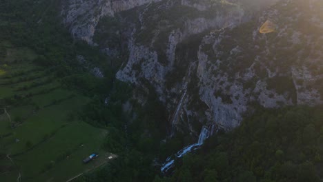 Captivating-landscape-featuring-Ujevara-E-Sotires-wild-waterfalls,-surrounded-by-majestic-mountains-and-a-picturesque-canyon