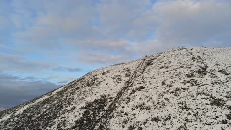 Snowy-winter-countryside-mountain-valley-panoramic-Welsh-hiking-national-park-aerial-rising-above-peak