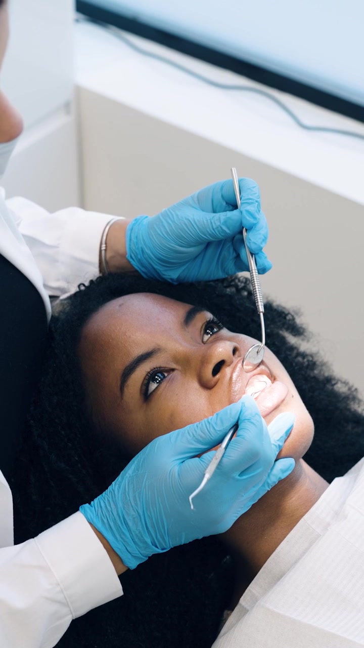 Dentista examinando os dentes de um paciente em uma clínica dentária