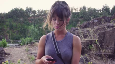 una linda chica moderna habla y mira su teléfono en medio de un parque
