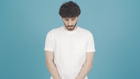 young man with unhappy guilty feeling bows his head.