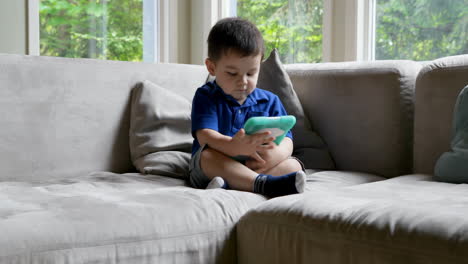 baby boy using digital table on sofa 4k