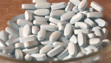 prescription pills in a glass bowl on a table