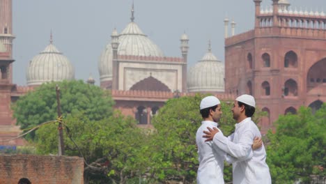 two young muslim men celebrating eid by hugging and greeting each other