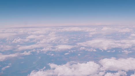 flying over the clouds, view from the plane on a blue sky and cumulus clouds