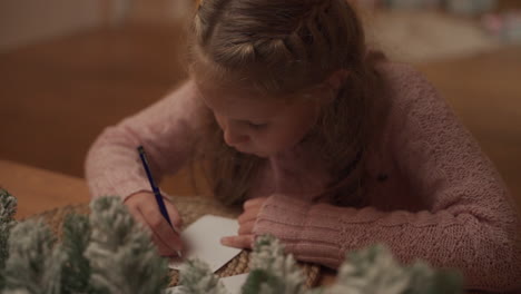 Kleines-Mädchen-Schreibt-Zu-Hause-Einen-Weihnachtsbrief-An-Den-Weihnachtsmann