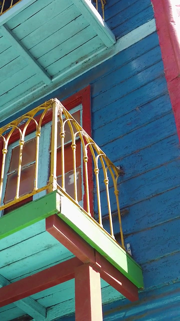 Ângulo baixo de casas e varandas coloridas do Caminito em La Boca, Buenos Aires, Argentina. Arquitetura de Viagem Vertical