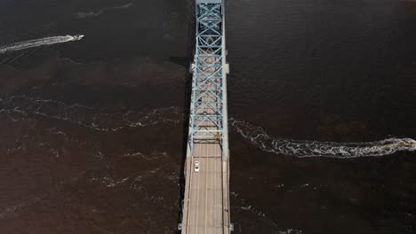 speed boats passing by of aerial drone view of downtown jacksonville overlooking bridge with cars passing by water white clouds