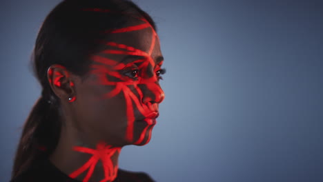 Facial-Recognition-Technology-Concept-As-Woman-Has-Red-Grid-Projected-Onto-Face-In-Studio